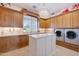 Laundry room with wood cabinets, quartz countertops, and a center island at 1233 E Salado Cir, Mesa, AZ 85203