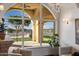 Living area with arched window showcasing pool and putting green at 1233 E Salado Cir, Mesa, AZ 85203