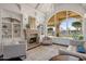 Bright living room with fireplace, built-in shelving, and large windows at 1233 E Salado Cir, Mesa, AZ 85203