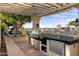 Outdoor kitchen with grill, refrigerator, and pergola; perfect for entertaining at 1233 E Salado Cir, Mesa, AZ 85203