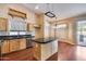 Kitchen with island, wood cabinets and granite countertops at 13778 W Cambridge Ave, Goodyear, AZ 85395