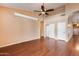 Living room with hardwood floors, ceiling fan and built-in shelves at 13778 W Cambridge Ave, Goodyear, AZ 85395