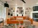 Living room with orange couch, gallery wall, and mid-century modern decor at 1425 E Desert Cove Ave # 24, Phoenix, AZ 85020