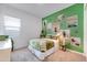 Cozy bedroom featuring a green accent wall and ample natural light at 15041 W Gray Fox Trl, Surprise, AZ 85387