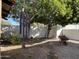 Lush backyard with mature trees, gravel landscaping, and a winding brick pathway at 15240 N 51St St, Scottsdale, AZ 85254