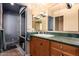 Bathroom featuring custom walk-in shower and a dark-stained vanity with green marble countertop at 15240 N 51St St, Scottsdale, AZ 85254