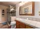 Bathroom featuring a tile countertop, framed mirror, and a glass-enclosed shower at 15240 N 51St St, Scottsdale, AZ 85254