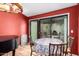 Warm dining area next to a piano featuring an outdoor view and red accent wall at 15240 N 51St St, Scottsdale, AZ 85254