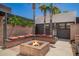 Inviting outdoor fire pit area surrounded by custom brick benches and lush landscaping, perfect for gatherings at 15240 N 51St St, Scottsdale, AZ 85254