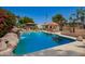 Large pool surrounded by lush landscaping, poolside seating and waterfall feature at 15240 N 51St St, Scottsdale, AZ 85254