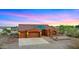 Beautiful desert home exterior with a three car garage and landscaped front yard at 19711 W Georgia Ave, Litchfield Park, AZ 85340