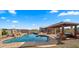 Inviting pool area with a pergola, fire pit, and comfortable seating at 19711 W Georgia Ave, Litchfield Park, AZ 85340