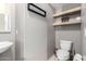 Small bathroom with pedestal sink, toilet and floating shelves at 2315 S 173Rd Dr, Goodyear, AZ 85338