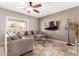 Living room with L-shaped sectional sofa and a large flat-screen TV at 2315 S 173Rd Dr, Goodyear, AZ 85338