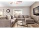 Living room with L-shaped sectional sofa and a large flat-screen TV at 2315 S 173Rd Dr, Goodyear, AZ 85338