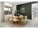 Modern dining room with an oval wooden table and dark green accent wall at 24241 W Agora Ln, Buckeye, AZ 85326
