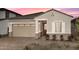 Tan one-story home with a two-car garage and landscaping at 24241 W Agora Ln, Buckeye, AZ 85326