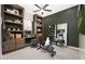 Home office with built-in shelving, a desk, and an exercise bike at 24241 W Agora Ln, Buckeye, AZ 85326