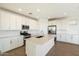 Modern kitchen with white cabinets, island, and stainless steel appliances at 31957 N 125Th Ave, Peoria, AZ 85383
