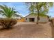 Large backyard with desert landscaping, including mature trees and partial block wall fencing for privacy at 42374 W Avella Dr, Maricopa, AZ 85138