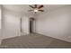 Bedroom features new carpeting, neutral walls, ceiling fan, and walk-in closet at 42374 W Avella Dr, Maricopa, AZ 85138