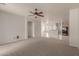 Open-concept living room shows neutral walls, new carpet, and access to kitchen at 42374 W Avella Dr, Maricopa, AZ 85138