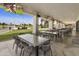 Outdoor patio with multiple tables and chairs, and TVs, overlooking a golf course at 563 W Champagne Dr, Chandler, AZ 85248