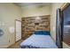 Simple bedroom with wood-like accent wall and tiled floor at 7318 W Jones Ave, Phoenix, AZ 85043