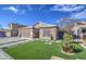 Front yard view of a house with stone exterior, artificial turf, and a walkway at 7318 W Jones Ave, Phoenix, AZ 85043