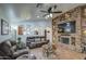 Open living room with a stone fireplace and a view into the kitchen area at 7318 W Jones Ave, Phoenix, AZ 85043
