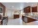 Modern kitchen with dark wood cabinets, granite counters, and appliances at 7785 E Luke Ln, Scottsdale, AZ 85250