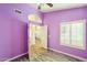 Bright bedroom with purple walls, wood-look floors, and window shutters at 7869 W Kristal Way, Glendale, AZ 85308