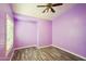 Simple bedroom with purple walls, wood-look floors, and window shutters at 7869 W Kristal Way, Glendale, AZ 85308