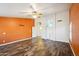 Living room with wood-look floors and orange accent wall at 7869 W Kristal Way, Glendale, AZ 85308