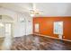 Living room with wood-look floors and orange accent wall at 7869 W Kristal Way, Glendale, AZ 85308