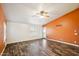 Living room with wood-look floors and orange accent wall at 7869 W Kristal Way, Glendale, AZ 85308