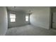 Spacious carpeted bedroom with two windows providing natural light and a neutral color palette at 11453 E Utah Ave, Mesa, AZ 85212