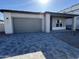 New construction home with gray garage doors and a paved driveway at 11453 E Utah Ave, Mesa, AZ 85212