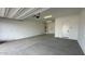 Spacious, unfinished garage with concrete floor, white walls and an automatic door opener at 11453 E Utah Ave, Mesa, AZ 85212