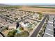 Aerial view of a house with solar panels and a pool in a residential neighborhood with farmland visible at 12053 N 157Th Ave, Surprise, AZ 85379