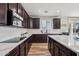 Modern kitchen with dark cabinetry, quartz countertops, and stainless steel appliances at 12053 N 157Th Ave, Surprise, AZ 85379