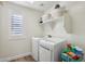 Bright laundry room with washer, dryer, and built-in shelving at 12053 N 157Th Ave, Surprise, AZ 85379