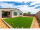 Artificial turf backyard with playground equipment and a covered patio at 12105 W Luxton Ln, Avondale, AZ 85323