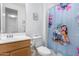 Clean bathroom with wood vanity and fun cartoon-themed shower curtain at 12105 W Luxton Ln, Avondale, AZ 85323