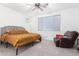 Spacious bedroom with gray headboard and large window, and a relaxing armchair at 12105 W Luxton Ln, Avondale, AZ 85323