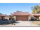 Tan stucco house with brown garage door and desert landscaping at 12234 S Shoshoni Dr, Phoenix, AZ 85044