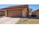 Attached garage with brown door and address number 1234 at 12234 S Shoshoni Dr, Phoenix, AZ 85044