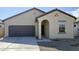 Tan house with brown garage door, front entrance, and small landscaping at 13151 E Verbina Ln, Florence, AZ 85132