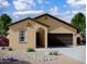 Tan house with brown garage door and desert landscaping at 13151 E Verbina Ln, Florence, AZ 85132