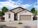 Single-story home with tan exterior, brown roof, and a two-car garage at 13165 E Verbina Ln, Florence, AZ 85132